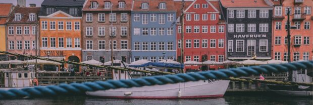 Colorful Denmark cityscape with historic buildings and sailboats along the waterfront