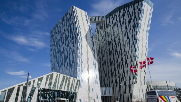 Modern Danish architecture with Danish flags waving under a clear blue sky in Denmark