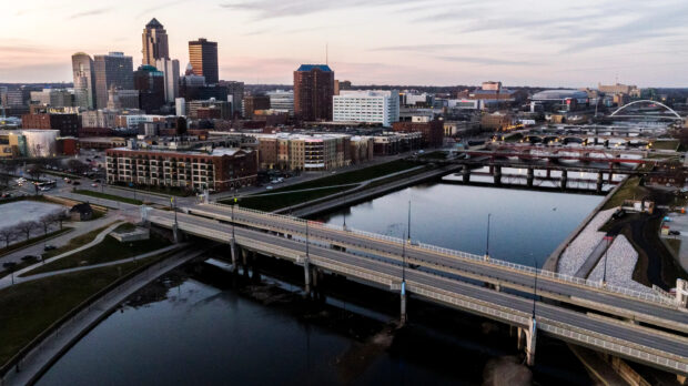 A view of Des Moines city skyline with bridges over the river at dusk