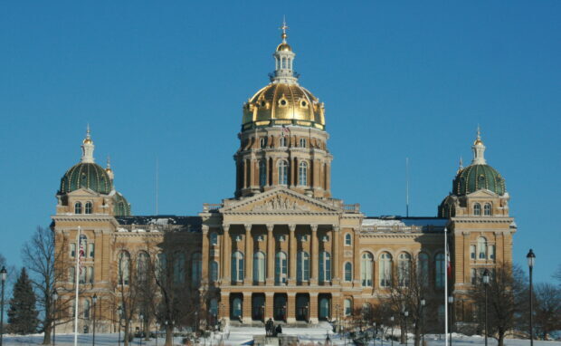 The golden dome and historic architecture of Des Moines Capitol building on a clear winter day
