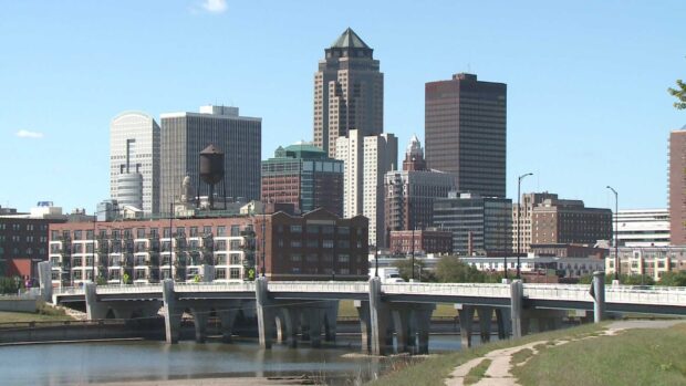 The Des Moines skyline with buildings and a bridge over a river on a clear day
