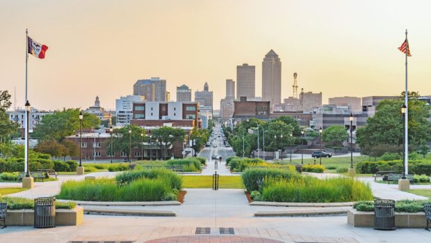View of downtown Des Moines cityscape with green park and flags in the foreground