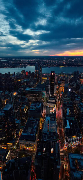 City skyline of Des Moines at dusk with illuminated buildings and cloudy sky