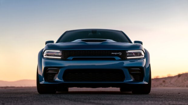 Blue Dodge Charger with sleek design and aggressive front grille at sunset