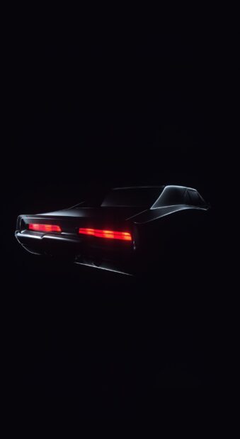 Rear view of a sleek Dodge Charger with glowing red taillights in the dark