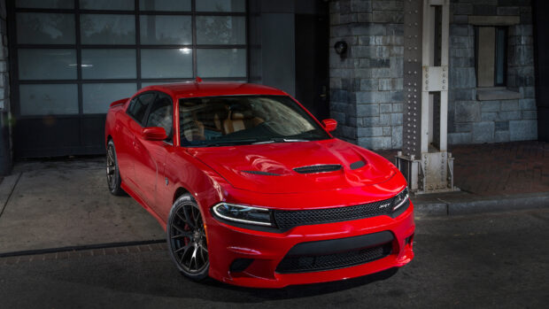 A red Dodge Charger parked in an urban setting showcasing its sleek design and sporty features