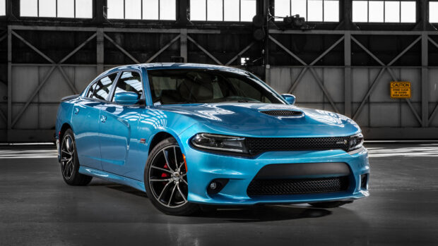 Blue Dodge Charger parked inside an industrial warehouse with reflective surfaces