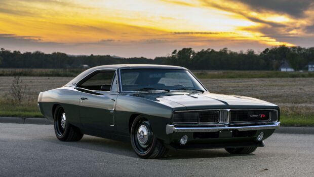 Classic Dodge Charger parked on road at sunset with scenic background