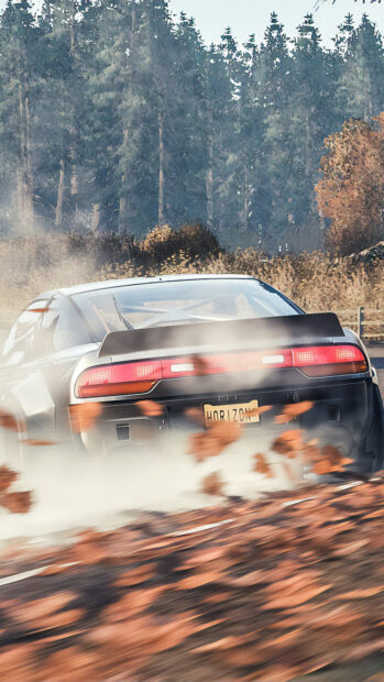 A drift car is sliding on a forest road with leaves flying around in the autumn breeze