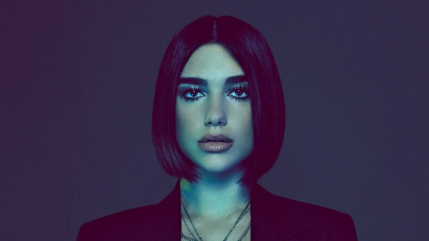 Dua Lipa close up portrait with short hair and dark blazer in blue lighting