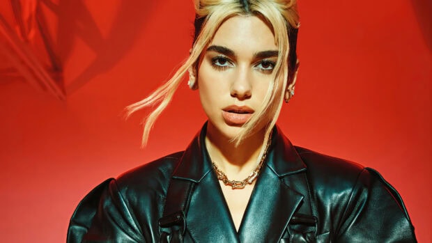Dua Lipa wearing a black leather jacket with blonde hair strands against a red background