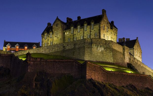 Edinburgh Castle stands majestically illuminated against a clear night sky