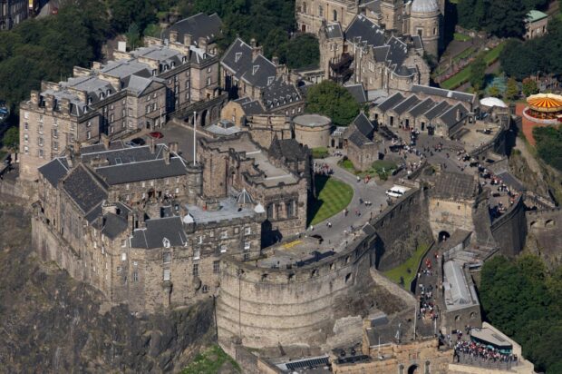 Aerial view of Edinburgh Castle historic fortress surrounded by greenery and visitors on pathways