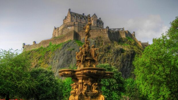 The historic castle in Edinburgh Scotland stands prominently on a rocky hill surrounded by lush greenery