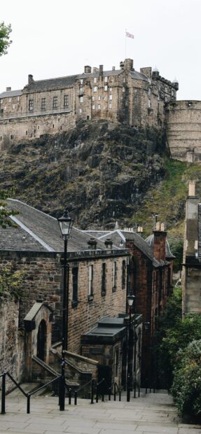 Historic stone fortress overlooking narrow cobblestone street in Edinburgh Scotland