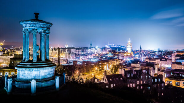 The Edinburgh cityscape with the Dugald Stewart monument lit at night in Scotland
