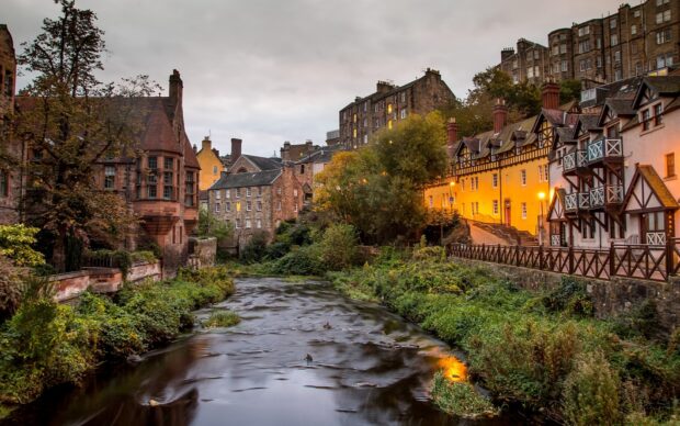 A peaceful scene of Edinburgh Scotland with historic buildings lining a river in autumn