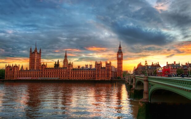The historic architecture of England with Big Ben and the Houses of Parliament at sunset reflecting on the river