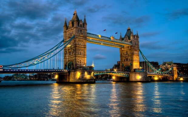 Tower Bridge at dusk with lights reflecting on the river in England