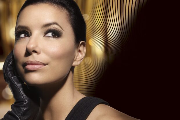 Eva Longoria wearing a black glove and looking thoughtfully to the side in a close up shot