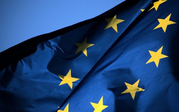 Close up of European Union flag with yellow stars on blue background