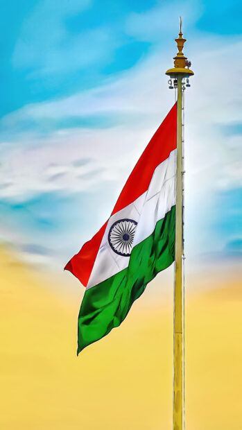 Indian flag waving on a flagpole under a blue and yellow sky