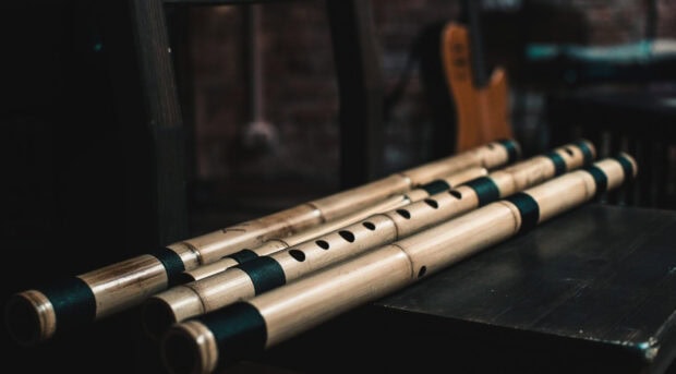 Traditional wooden flute instruments placed neatly on a dark surface in a music room