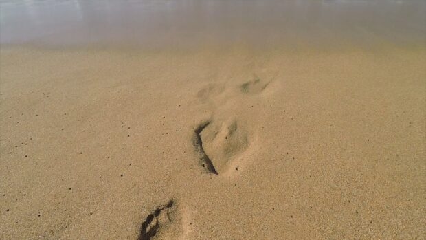 A clear footprint in the sand on a beach showing footprints in the sand