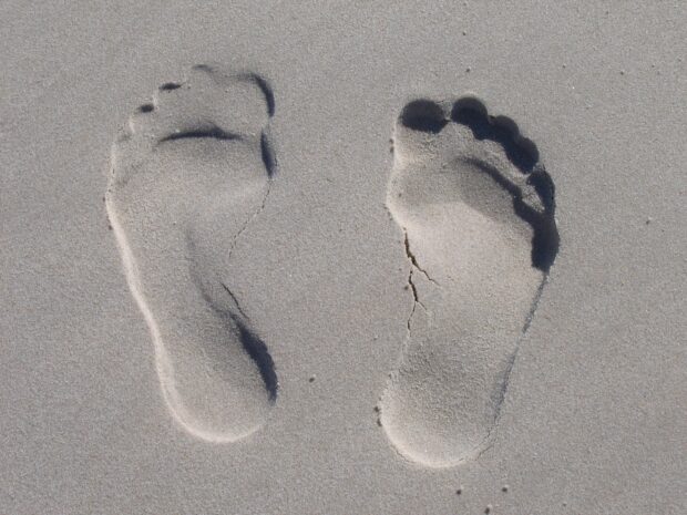 Two footprints in the sand showing clear footprints in the soft sand