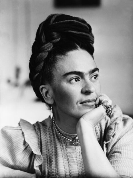 Frida Kahlo portrait with braided hair and jewelry looking thoughtful