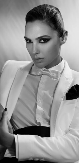 Gal Gadot wearing a white tuxedo with a bow tie in a black and white portrait