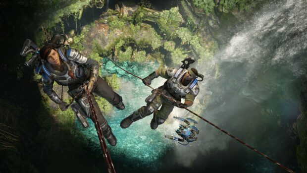Two Gears of War characters climbing ropes above a waterfall in a lush environment