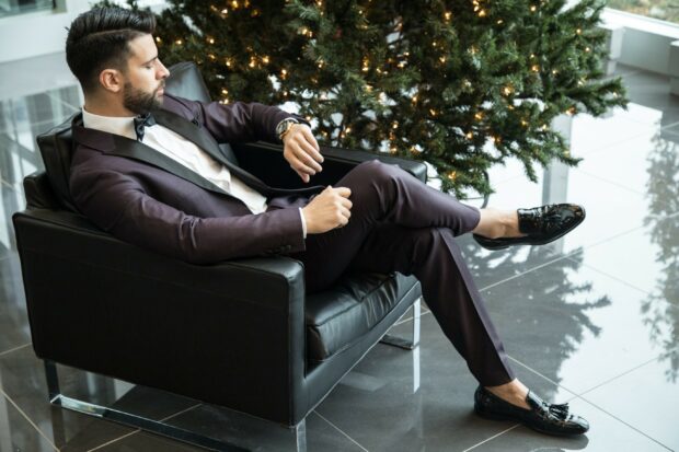 A stylish gentleman sitting relaxed in a modern chair wearing a classic suit