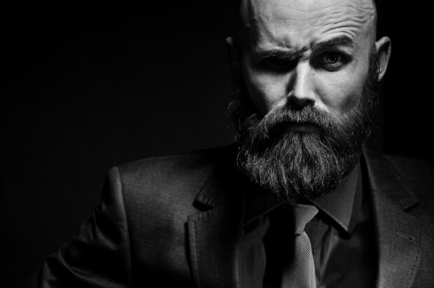 Bearded gentleman in a suit showing a serious expression