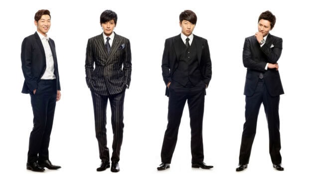Four gentleman wearing stylish suits standing confidently together