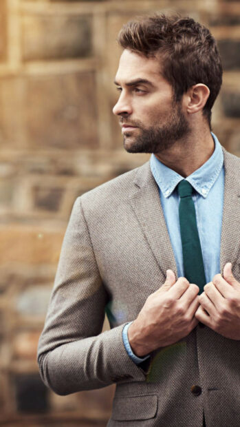 Stylish gentleman wearing a suit and tie looking away confidently