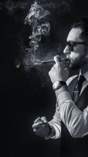Man in a suit smoking a cigar with smoke rising in the air