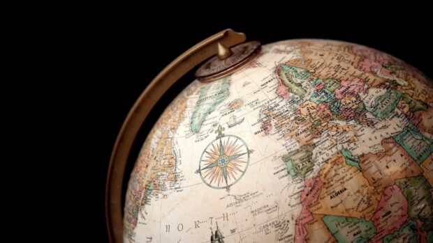 A vintage globe showing detailed geography of Europe and surrounding regions with a compass rose