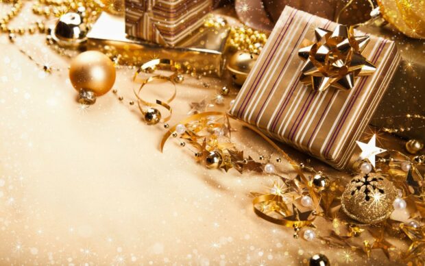 A festive arrangement of gifts and decorations with golden stars and ribbons on a shiny surface