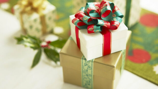 A close up of gifts with decorative ribbons placed on a table with festive background