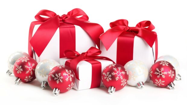 White boxes with red ribbons surrounded by holiday gifts on a white surface