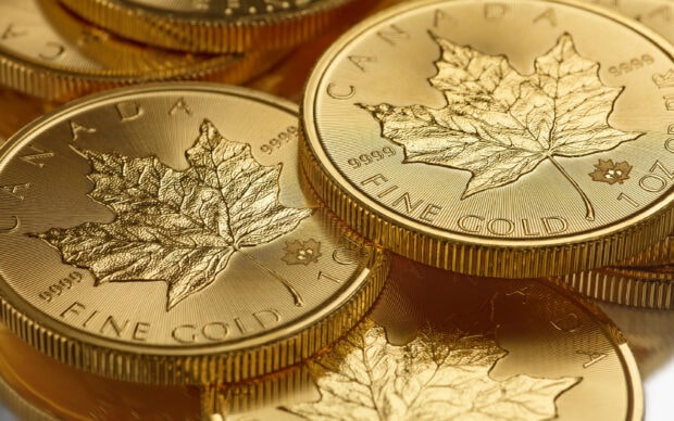 Close up of gold coins with detailed maple leaf design and fine gold engraving