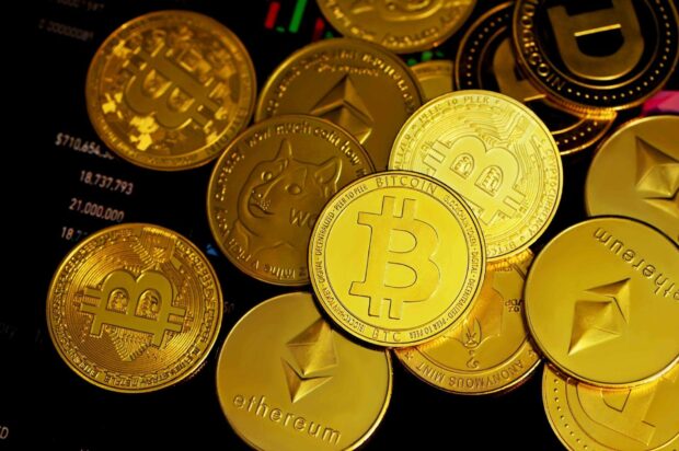 Shiny gold coins featuring bitcoin and ethereum symbols on a dark surface
