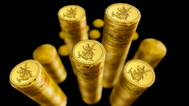 Stacks of gold coins with intricate designs on top viewed from above