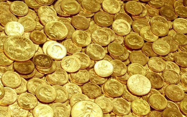A close up view of various gold coins displaying intricate details and designs