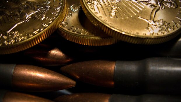 Close up view of gold coins with copper bullets stacked together