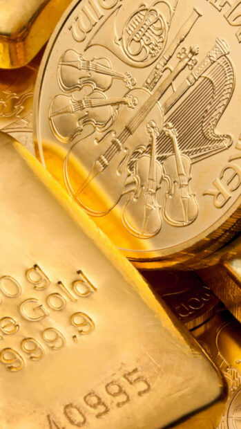 A close up of gold coins and a gold bar with musical instruments engraving included