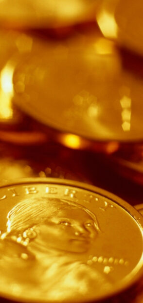 Close up of gold coins featuring a woman's face and the word liberty