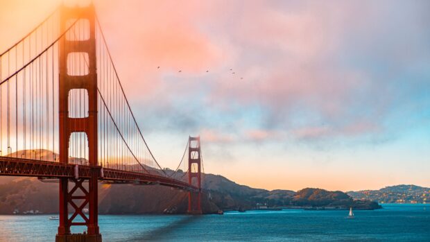 Golden Gate Bridge with a beautiful sunset sky and birds flying over the ocean