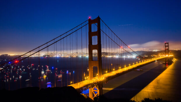 Golden Gate Bridge at night with city lights and a clear sky